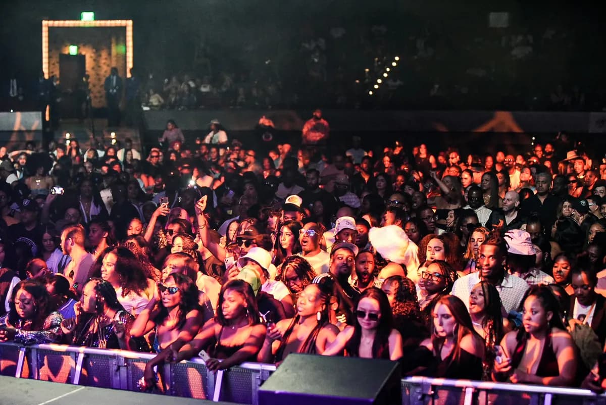 Large crowd gathered at the front rail under warm concert lighting