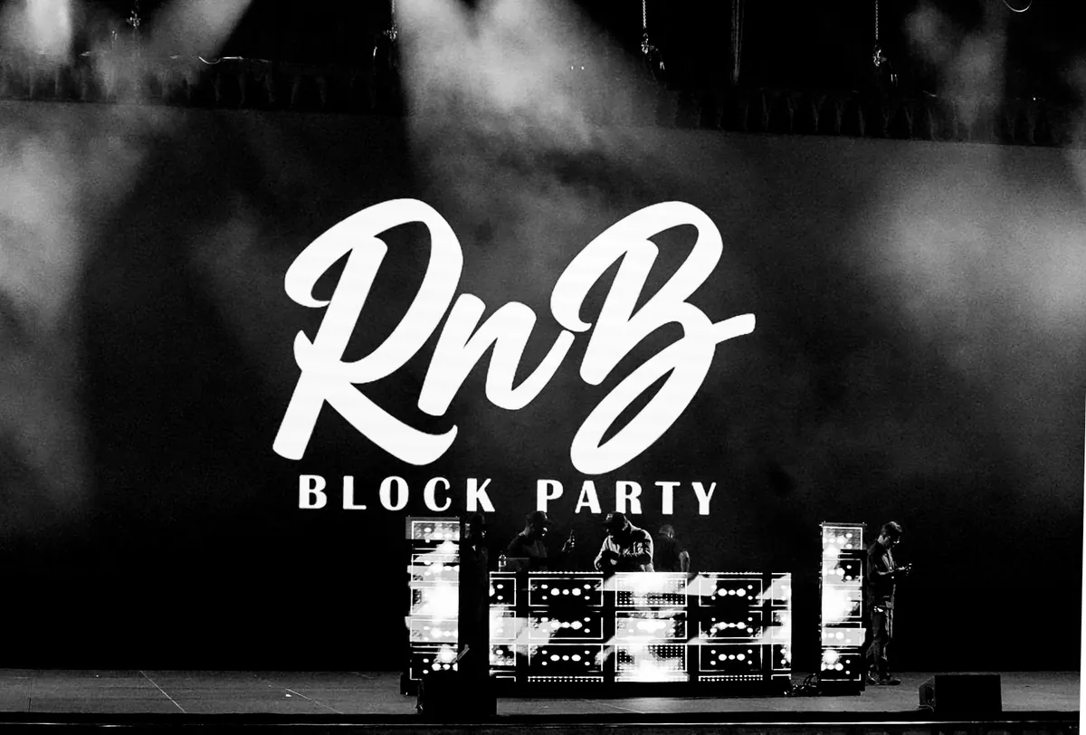 DJs performing on stage in front of a large RnB Block Party logo